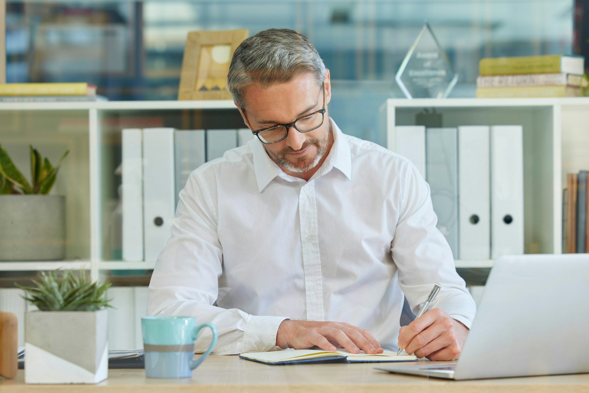 businessman writing in notebook and working in accounting firm for business tax compliance and fi