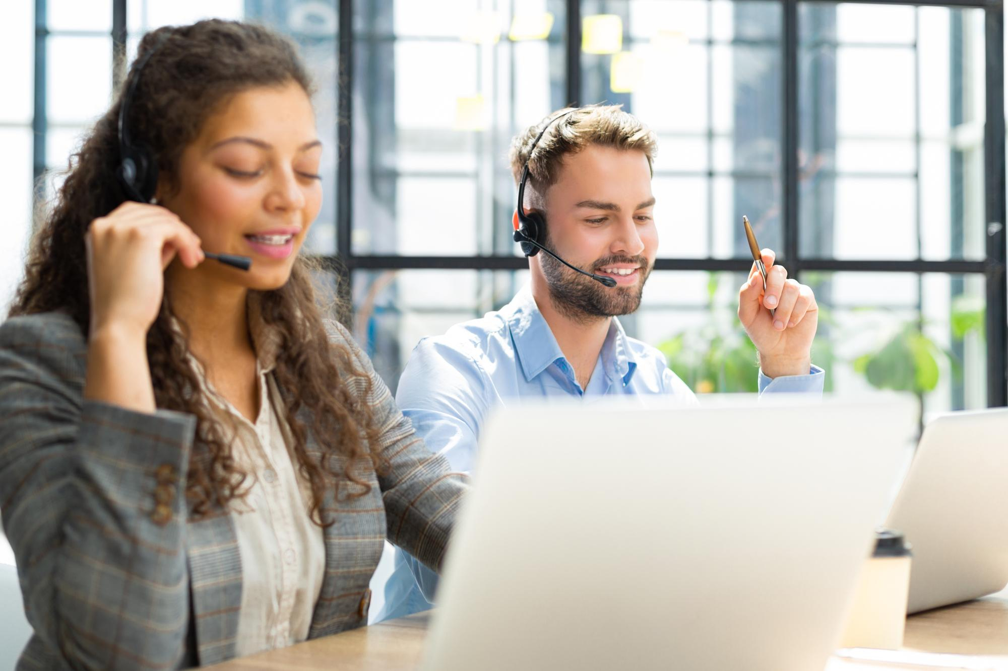 portrait call center worker accompanied by his team smiling customer support operator work